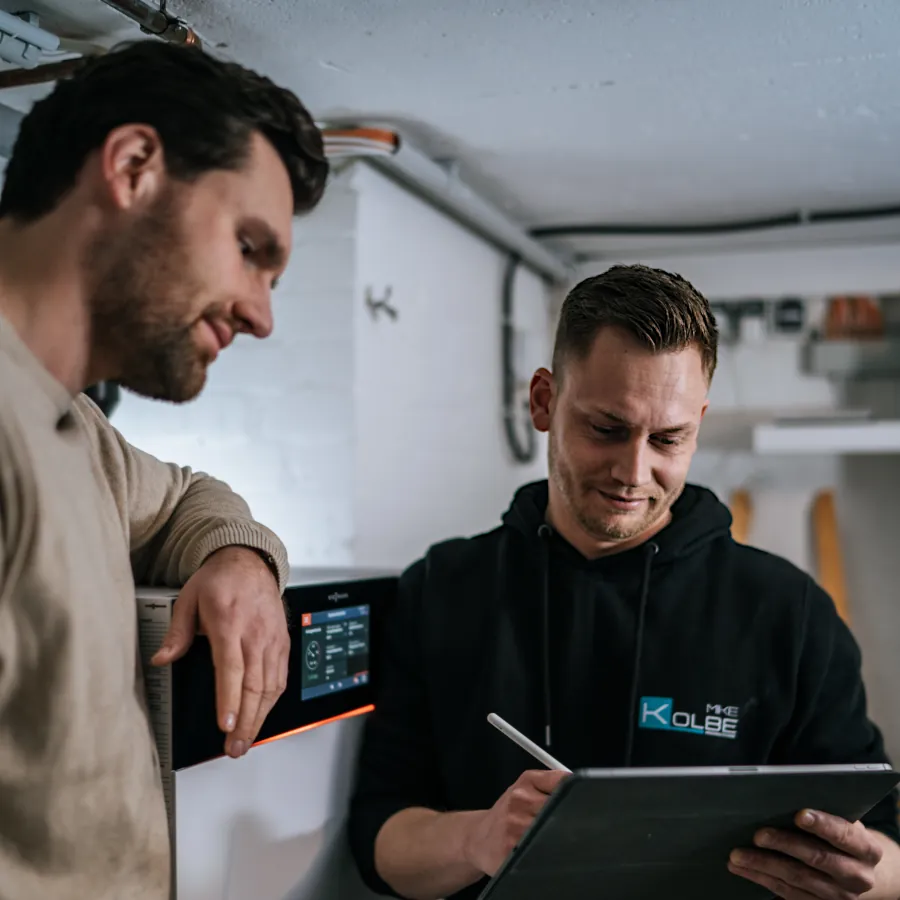 Firmengründer Mike Kolbe demonstriert einem Kunden etwas auf einem Tablet